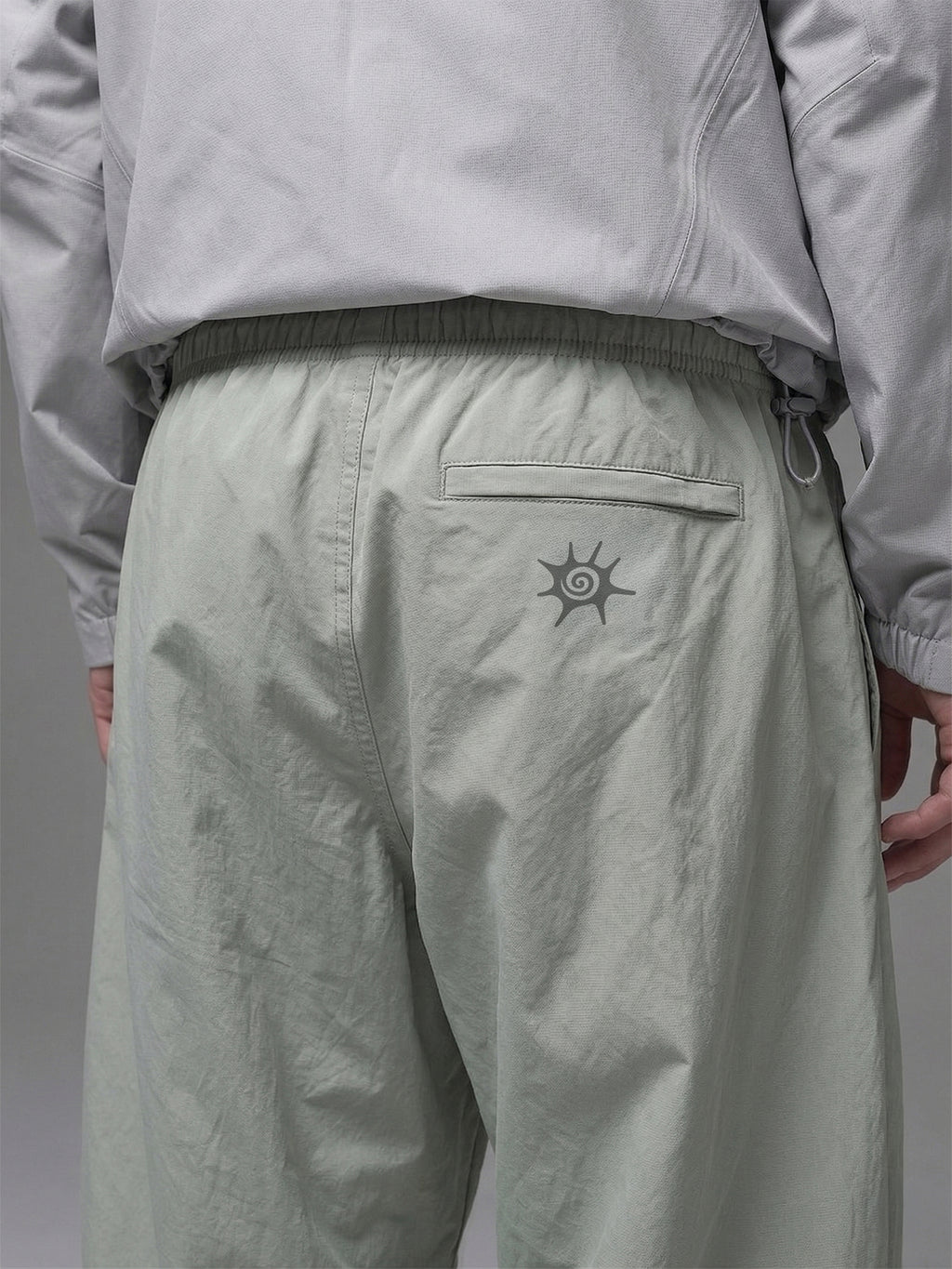 Detalle de la cintura elasticada y cinturón integrado del pantalón técnico SOLAN Trek para un ajuste personalizado en montaña. Logo reflectante SOLAN en pantalón técnico, diseñado para visibilidad y seguridad en trekking nocturno.