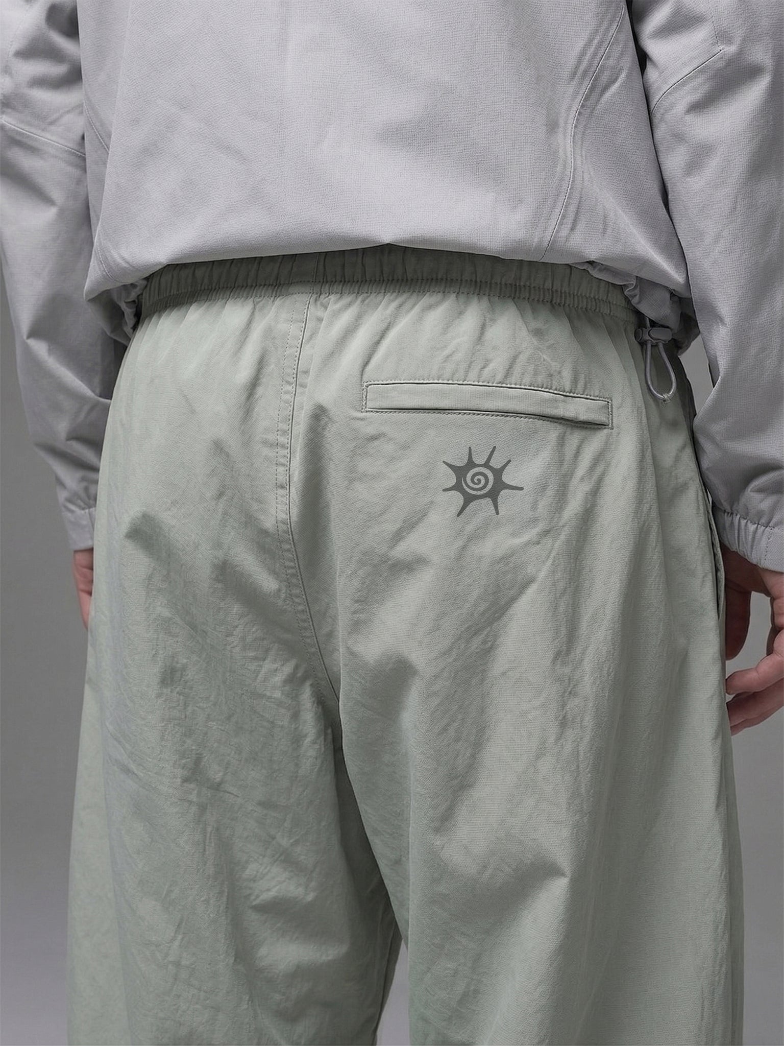 Detalle de la cintura elasticada y cinturón integrado del pantalón técnico SOLAN Trek para un ajuste personalizado en montaña. Logo reflectante SOLAN en pantalón técnico, diseñado para visibilidad y seguridad en trekking nocturno.