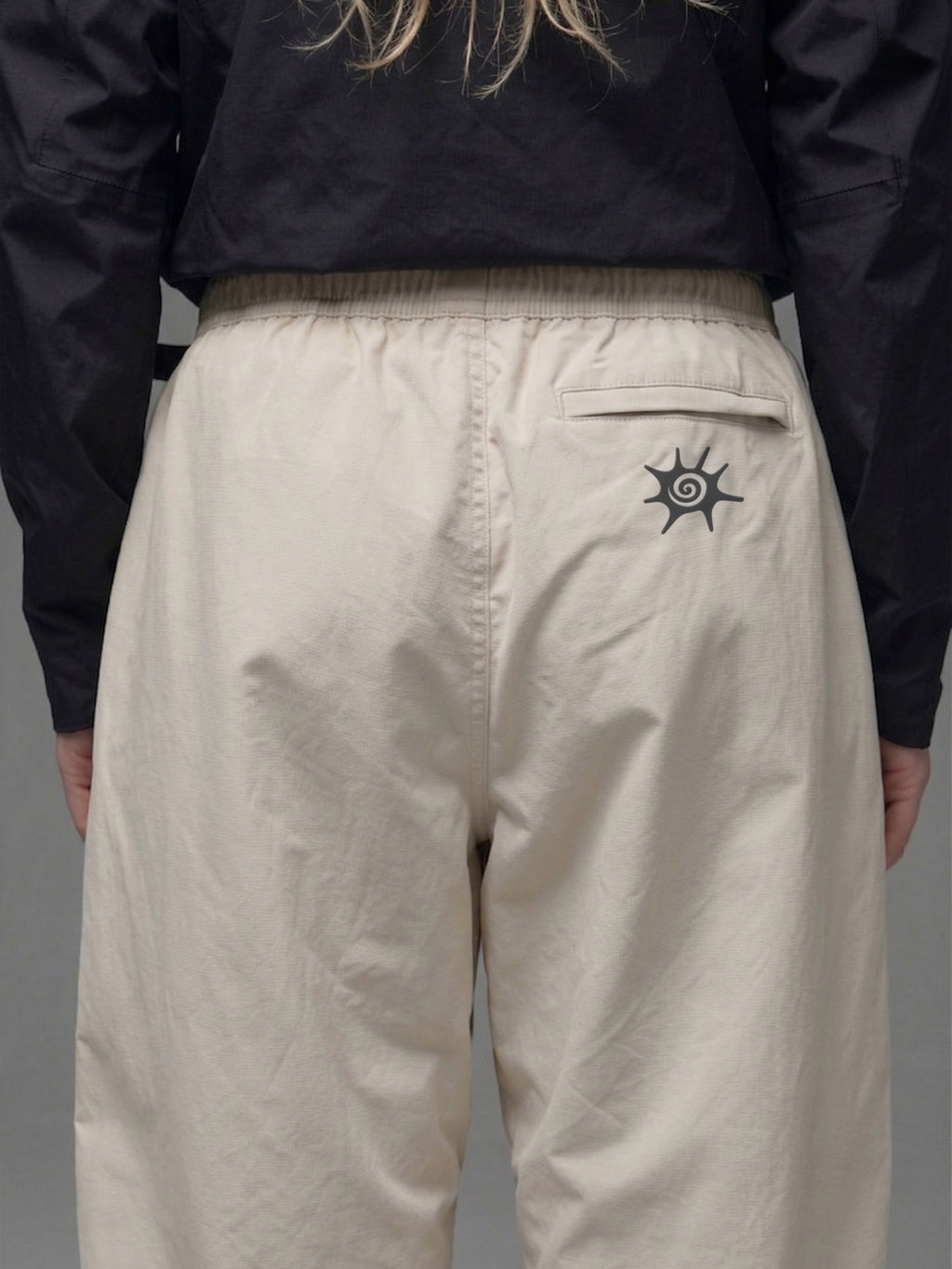 Detalle de la cintura elasticada y cinturón integrado del pantalón técnico SOLAN Trek para un ajuste personalizado en montaña. Logo reflectante SOLAN en pantalón técnico, diseñado para visibilidad y seguridad en trekking nocturno.